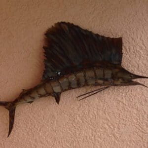 A metal fish hanging on the wall of a room.