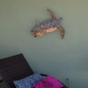 A turtle is flying through the air above a bed.