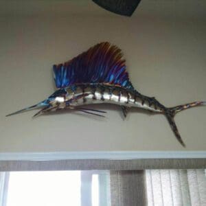 A metal fish sculpture hanging on the wall.