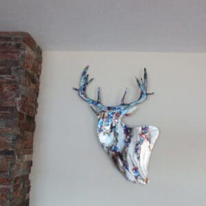 A deer head mounted to the side of a wall.